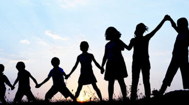 Kids with arms up together in nature